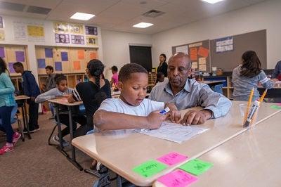 A student and teacher work together in a classroom